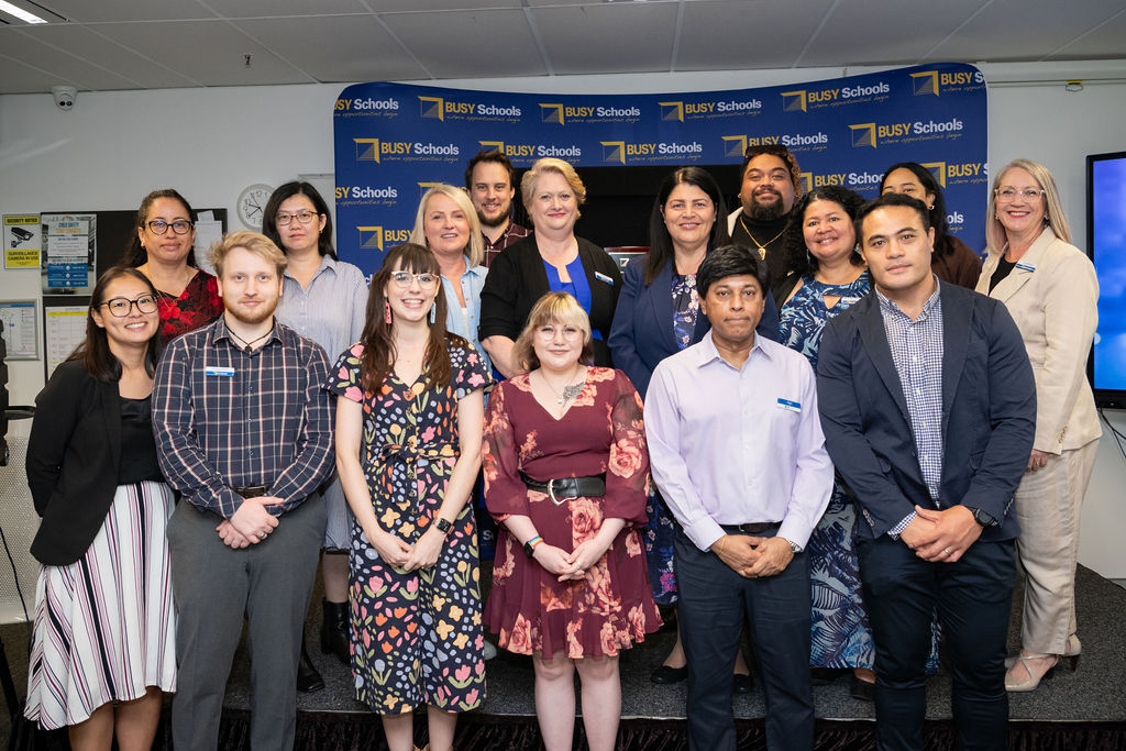 Group of people standing in front of BUSY School media board
